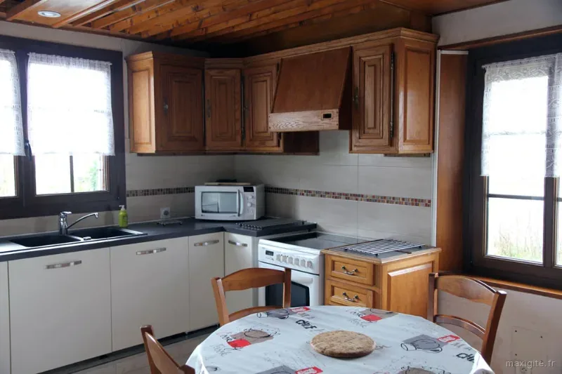 Cuisine équipée avec plan de travail et rangements en bois clair