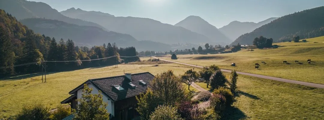 Gîte de groupe Gîtes Le Moulin à La Compôte — Vue aérienne du gîte le Moulin isolé au milieu des prairies avec montagnes des Bauges en fond, capacité 15 personnes