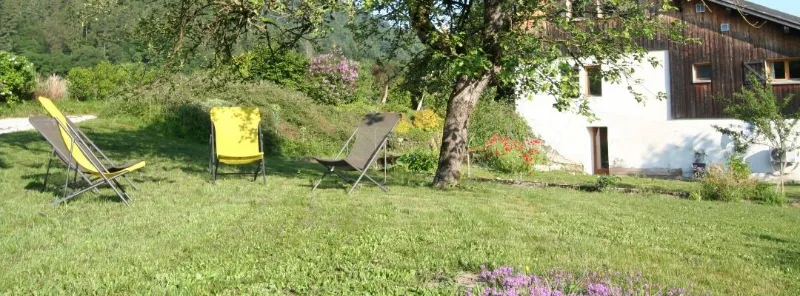 Jardin arboré avec chaises longues pour se détendre face aux prairies environnantes