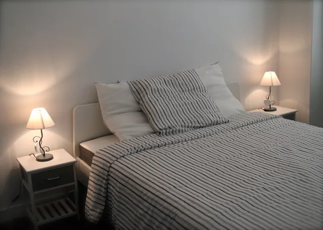 Chambre double lumineuse avec lampes de chevet et literie rayée
