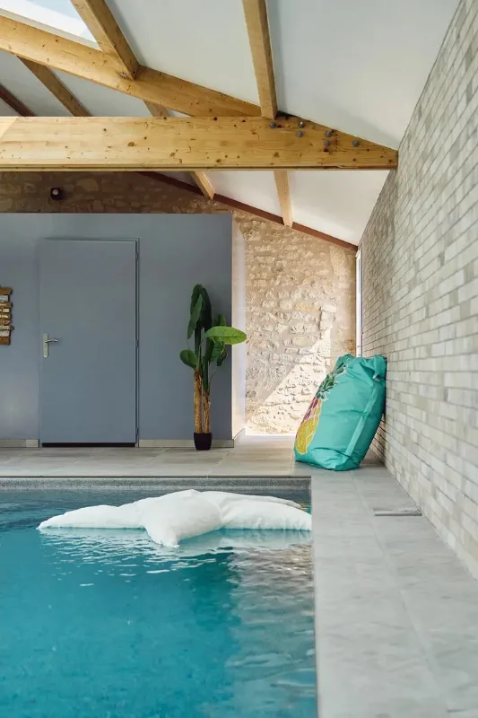 Piscine intérieure chauffée sous charpente en bois