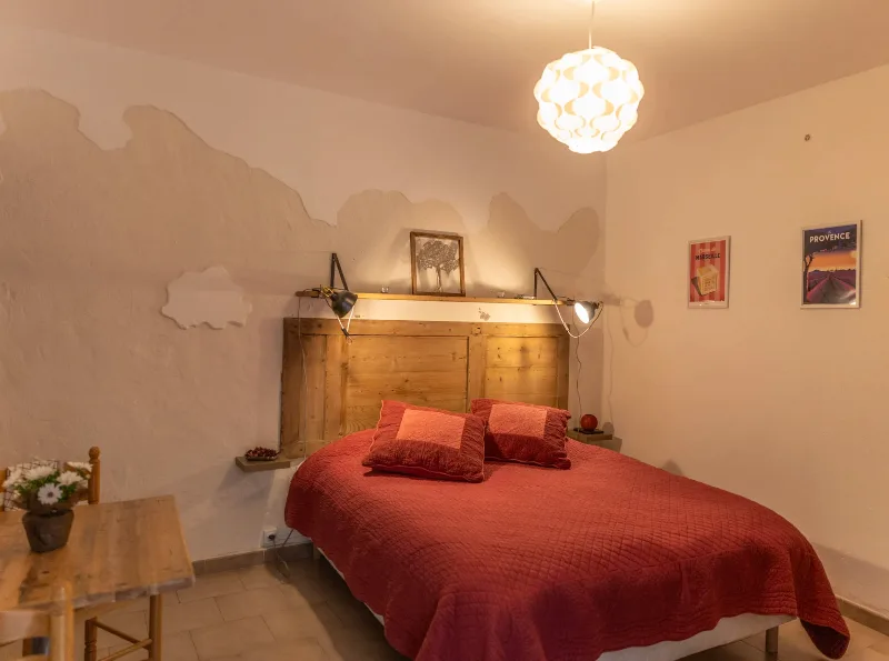 Chambre avec tête de lit en bois et ambiance provençale