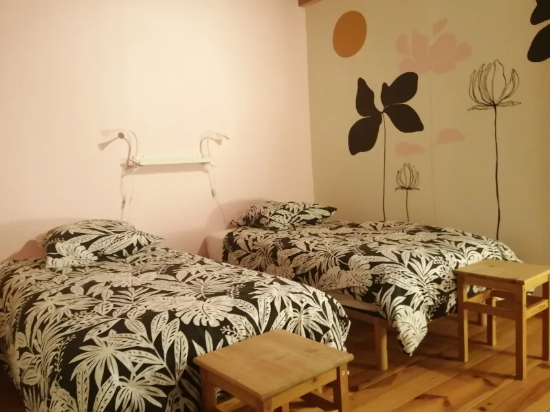 Chambre avec deux lits simples et décoration florale