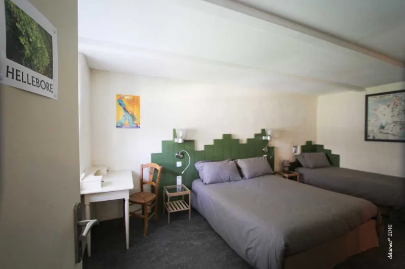 Chambre avec deux lits simples et tête de lit verte originale