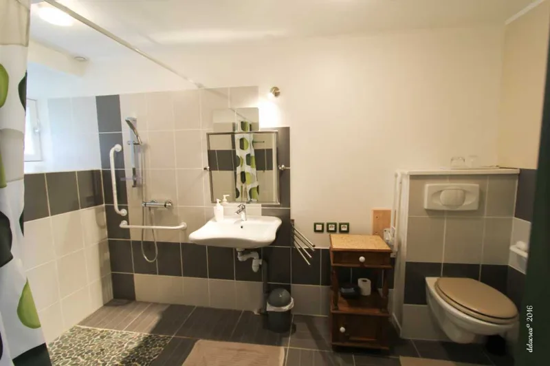 Salle de bain adaptée PMR avec douche à l'italienne et barres d'appui