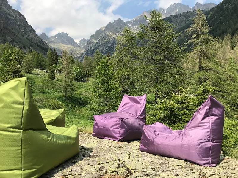 Terrasse extérieure avec poufs colorés face aux montagnes, espace détente au grand air