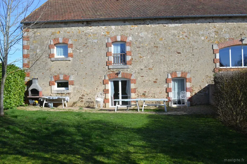 Gîte de groupe Chez Laure et Anthony à Sidiailles — Façade en pierre du gîte avec terrasse, table et barbecue extérieur, capacité 25 personnes