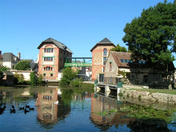 Gîte de groupe Les Grands Moulins à Graçay — Ancienne minoterie en brique et pierre au bord de la rivière du Fouzon, avec passerelle métallique, capacité 58 personnes