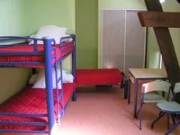 Chambre avec lits superposés et lit simple, sous charpente apparente