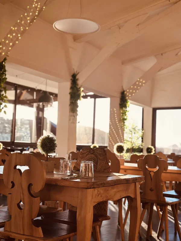 Salle de restaurant chaleureuse avec tables et chaises en bois sculpté, esprit montagnard