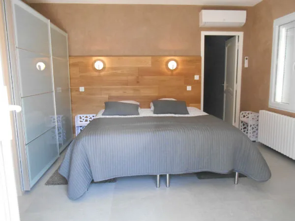 Chambre double avec dressing coulissant et tête de lit en bois