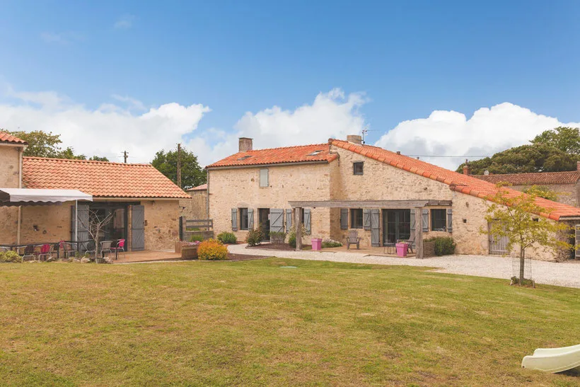 Gîte de groupe Gîte SO'délices à Saint-Étienne-du-Bois — Façade en pierre de l'ancienne ferme vendéenne avec grand jardin arboré, capacité 15 personnes