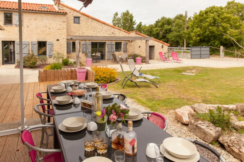 Terrasse extérieure avec grande tablée dressée pour un repas de groupe