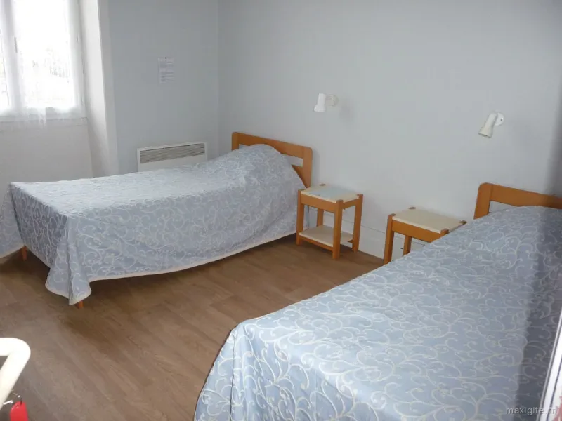 Chambre avec deux lits simples et couvre-lits assortis