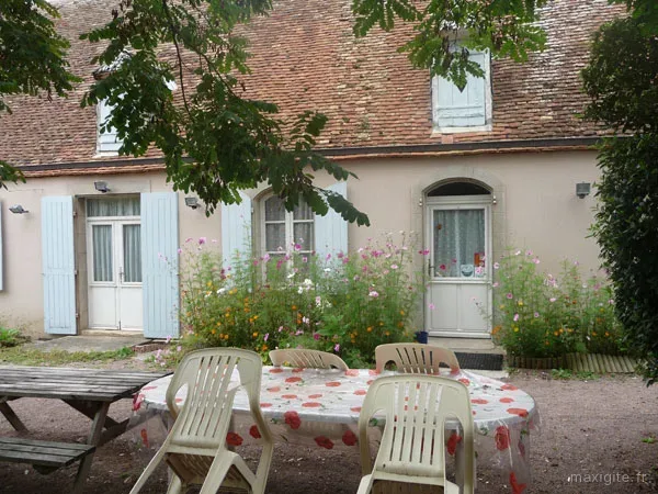 Terrasse extérieure ombragée avec table et chaises de jardin