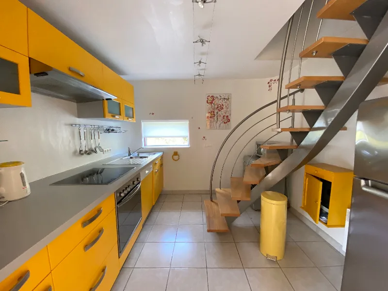 Les Gîtes du Torgan – MassacCuisine jaune équipée avec hotte et escalier en colimaçon