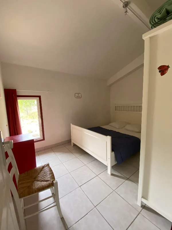 Les Gîtes du Torgan – MassacChambre avec lit double, dessus de lit bleu marine et armoire blanche