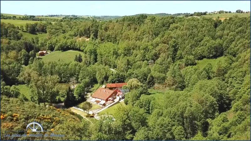 Vue aérienne de la grange en pierre nichée dans un vallon boisé