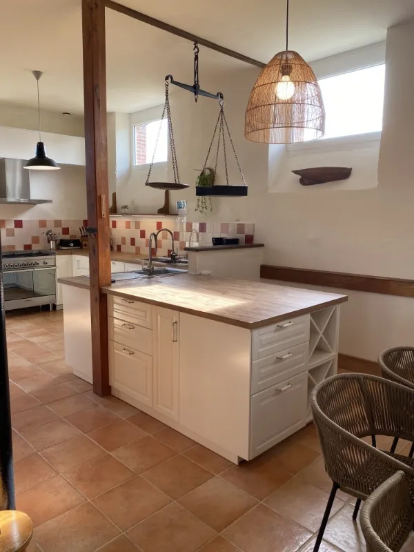 Cuisine blanche avec îlot central en bois et carrelage aux tons rouges
