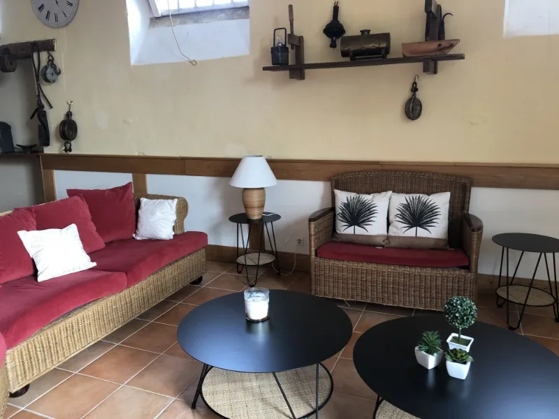 Salon avec canapé rouge en rotin et étagère décorative en bois