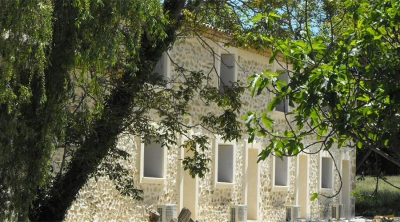Façade en pierre de la bastide provençale du XVIIIe siècle entourée de platanes