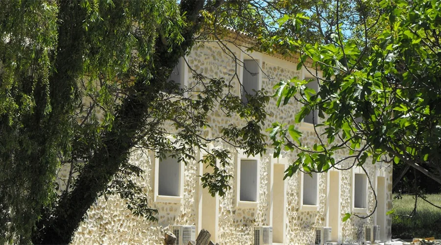 Gîte de groupe Domaine de Beauvezet à Lamanon — Façade en pierre de la bastide provençale du XVIIIe siècle entourée de platanes, capacité 26 personnes
