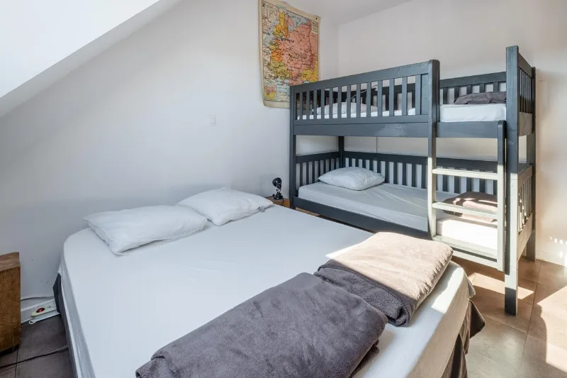 Chambre familiale à la décoration d'antan avec plusieurs lits pour le groupe