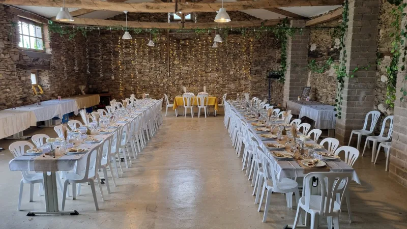 Grande salle de réception de 210 m2 dressée avec longues tables pour un mariage ou une cousinade