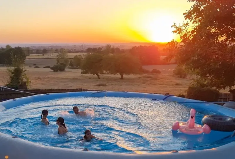 Piscine extérieure au coucher du soleil avec vue dégagée sur la campagne du Tarn