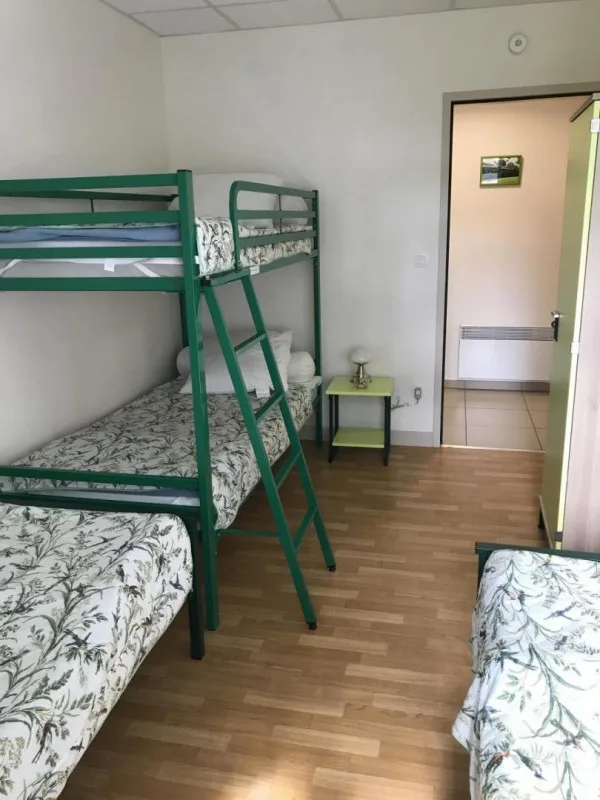 Chambre avec lits superposés et lits simples, parquet et grande armoire