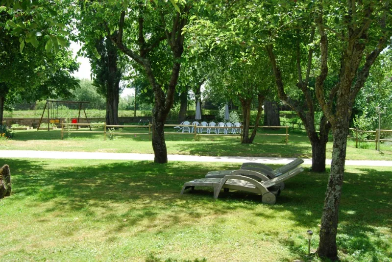 Jardin arboré et ombragé avec transats et espace de jeux