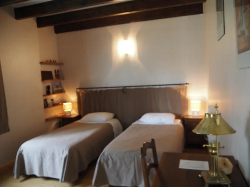 Chambre avec deux lits simples, tête de lit en tissu et éclairage tamisé