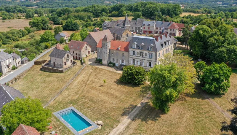 Vue aérienne du domaine et du château en pierre entouré de son parc arboré