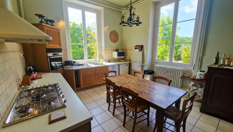 Cuisine équipée avec grande table en bois et vue sur le parc