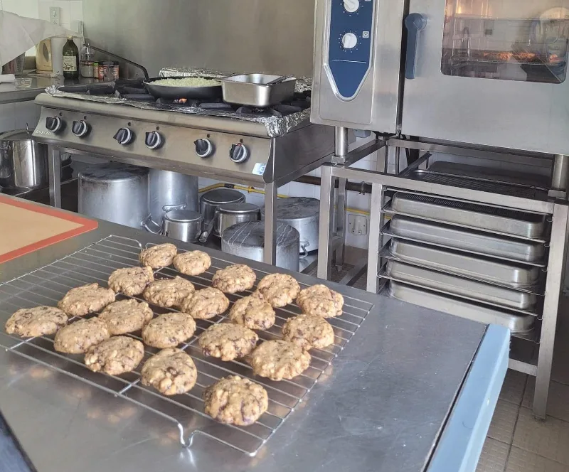 Cuisine professionnelle spacieuse avec piano de cuisson et four adaptés aux grands groupes