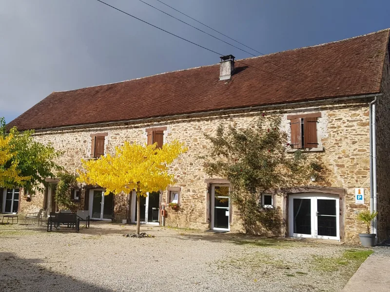 Longère en pierre du Limousin avec sa cour gravillonnée et ses arbres en automne