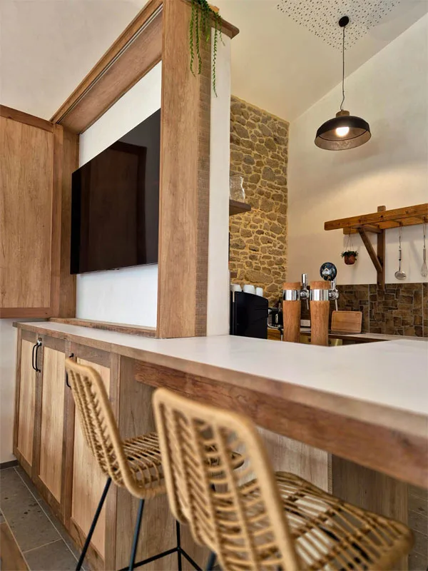 Bar avec tireuse à bière et coin cuisine en pierre apparente pour les soirées