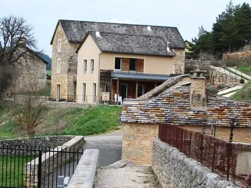 Façade en pierre du gîte La Chazelle avec toit à double pente et muret en pierres sèches