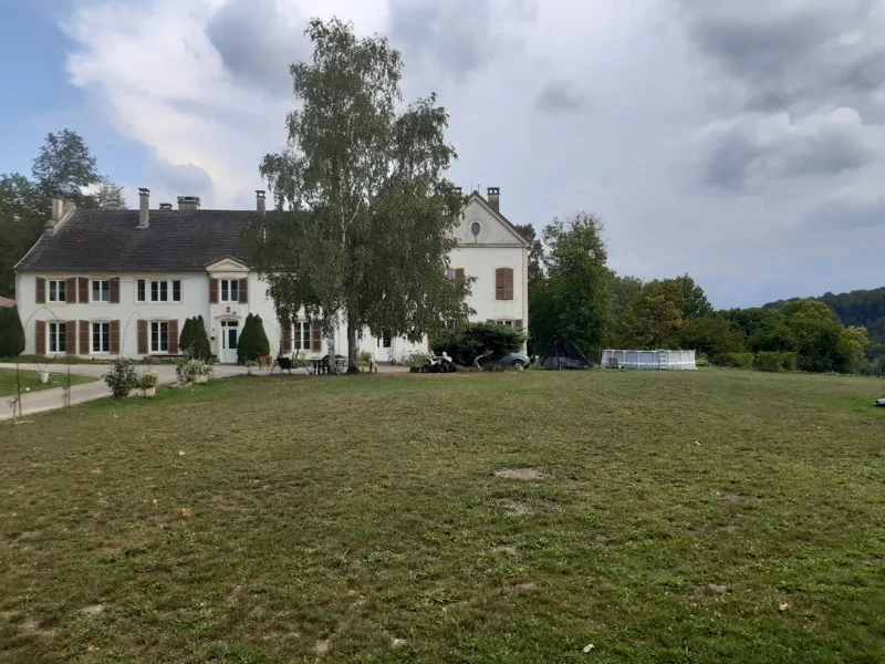 Façade en pierre du domaine avec vaste cour et entrée du corps de logis principal