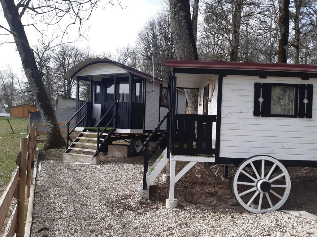 Roulotte en bois nichée dans la verdure du domaine, hébergement insolite pour deux personnes