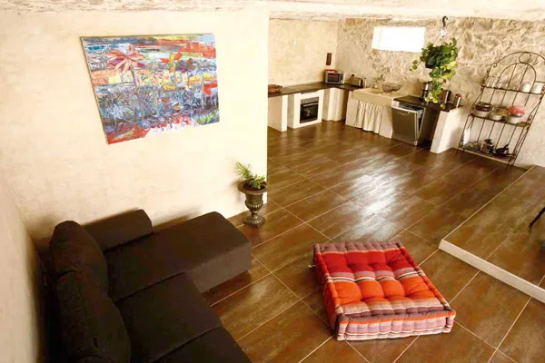 Salon avec tapis rouge, parquet en bois et vue en mezzanine sur l'étage