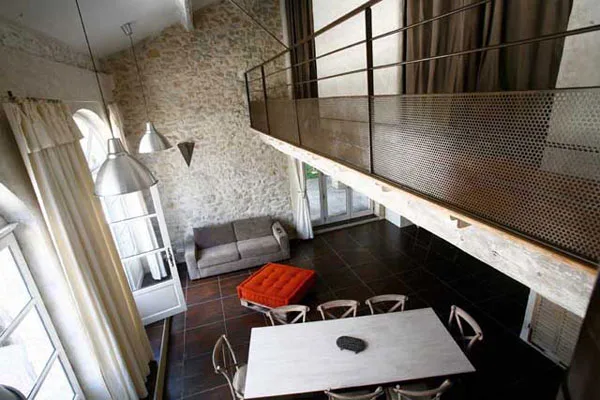 Cuisine équipée moderne avec table et chaises noires sous une mezzanine en bois