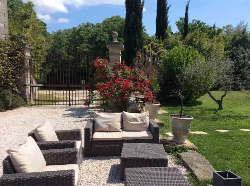 Terrasse extérieure ombragée avec salon de jardin et vue sur la piscine