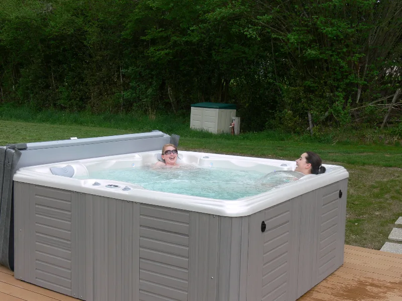 Jacuzzi extérieur entouré de verdure pour se détendre après une journée