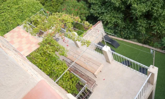 Vue aérienne de la terrasse ombragée avec pergola végétalisée et grande table conviviale