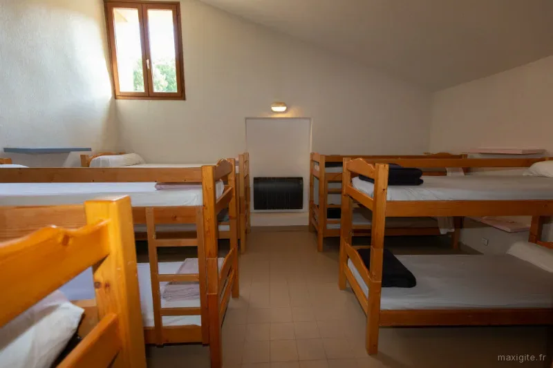 Dortoir de 12 couchages en lits superposés en bois sous les combles