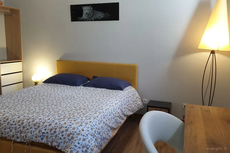 Chambre double avec lit à tête de lit jaune moutarde et bureau