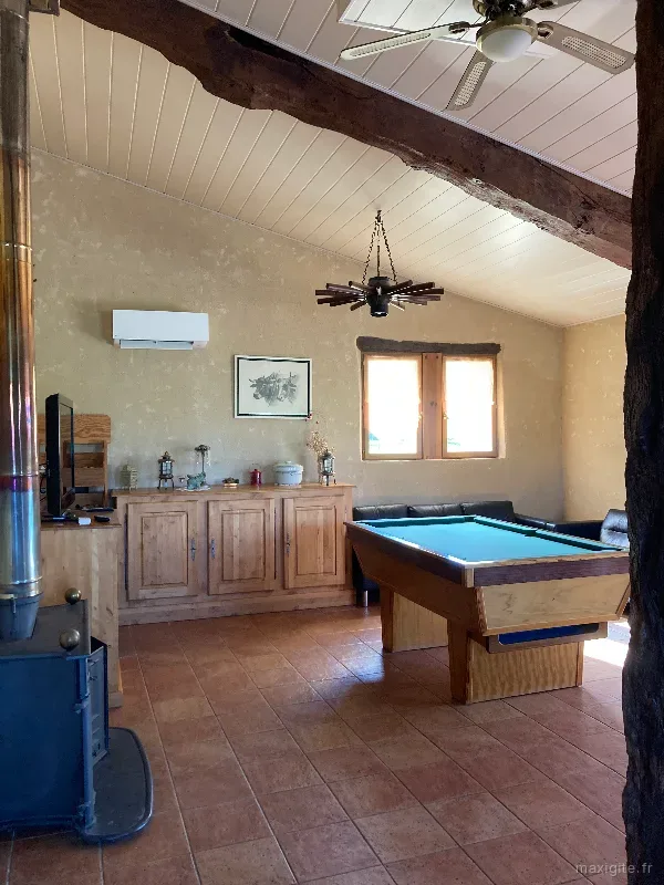 Salon avec cheminée, poêle à bois et billard pour les soirées entre convives