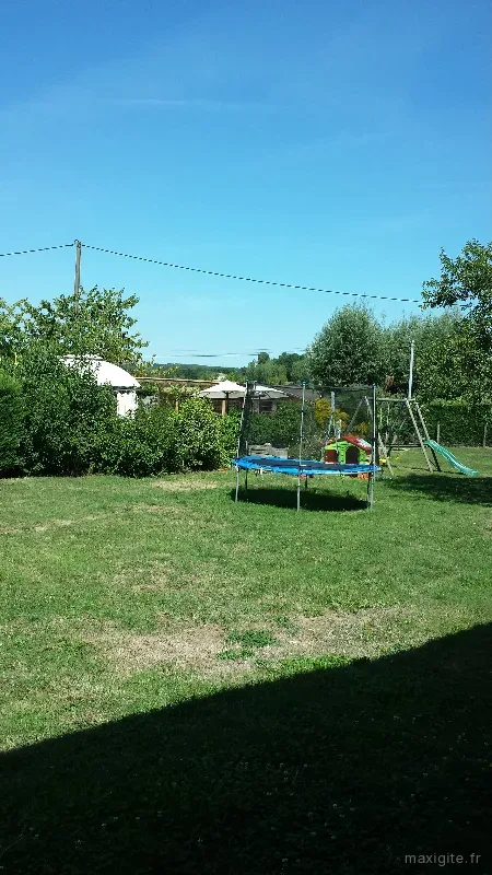 Grand jardin arboré avec trampoline pour les enfants et espace de détente