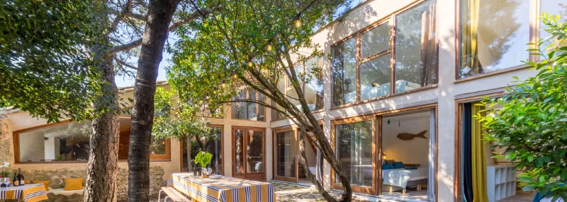 Patio ombragé sous les arbres avec espace repas extérieur pour les grandes tablées